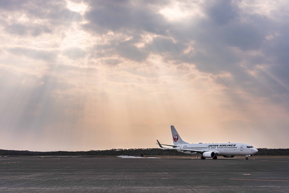 雲間から差す光芒と航空機